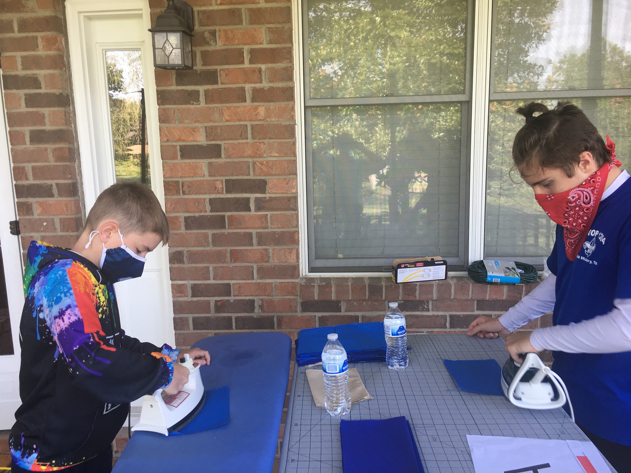 Younger scouts helping with ironing fabric