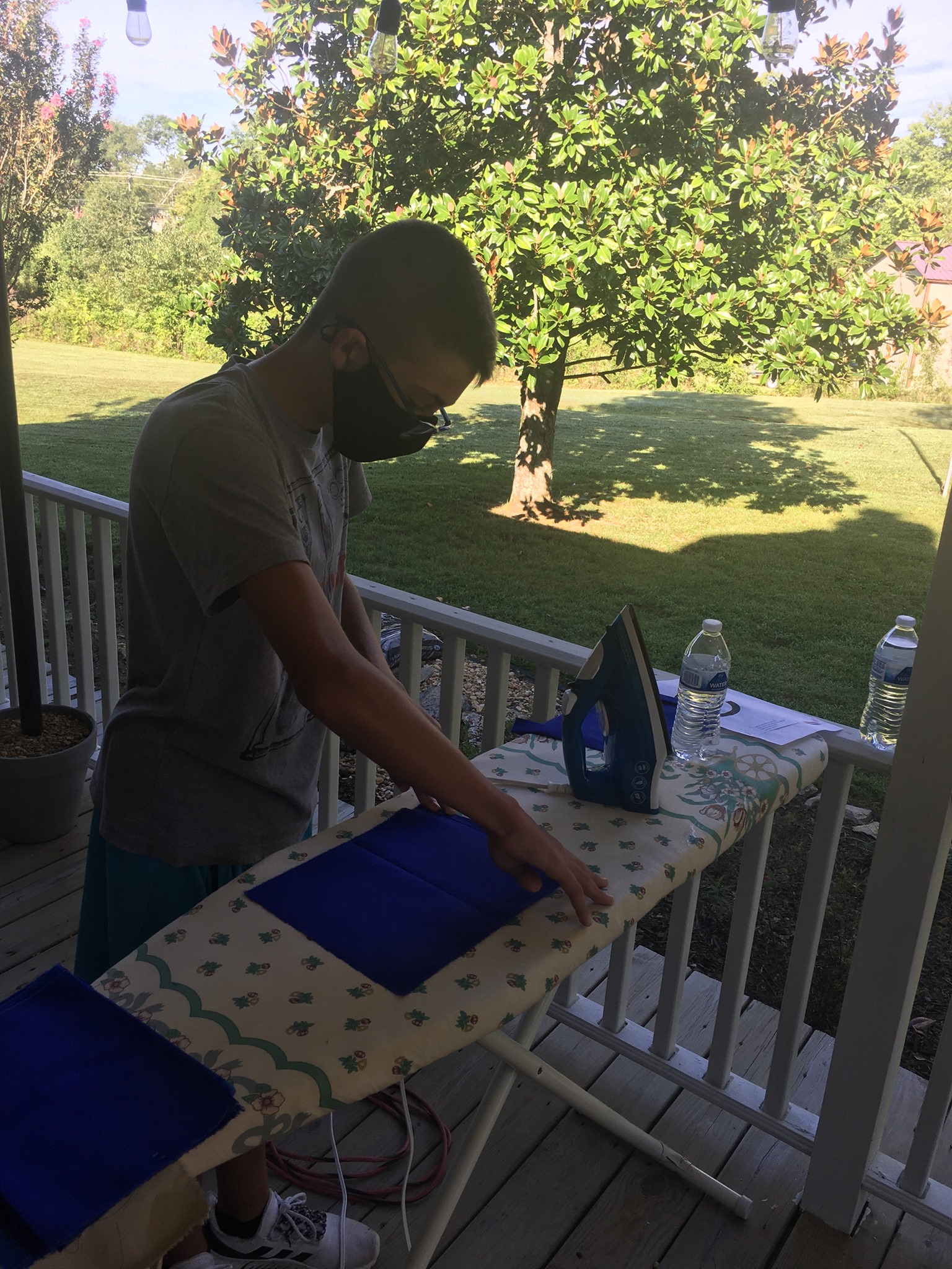 A volunteer carefully ironing a mask